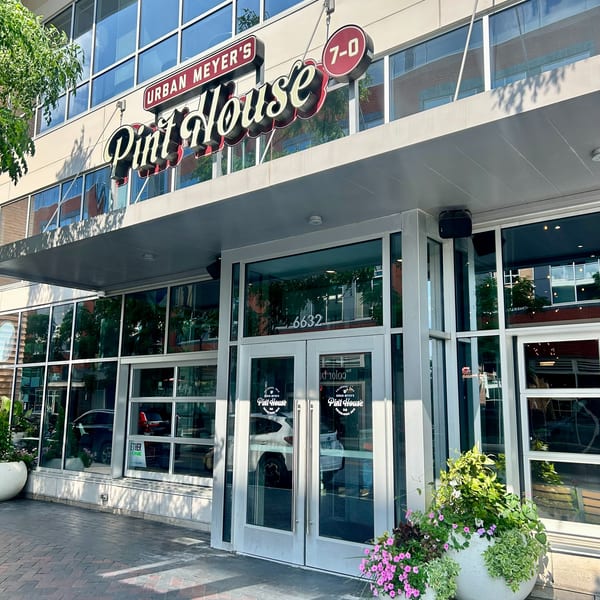 Exterior of Urban Meyer's Pint House, a modern building with large windows and a prominent sign.