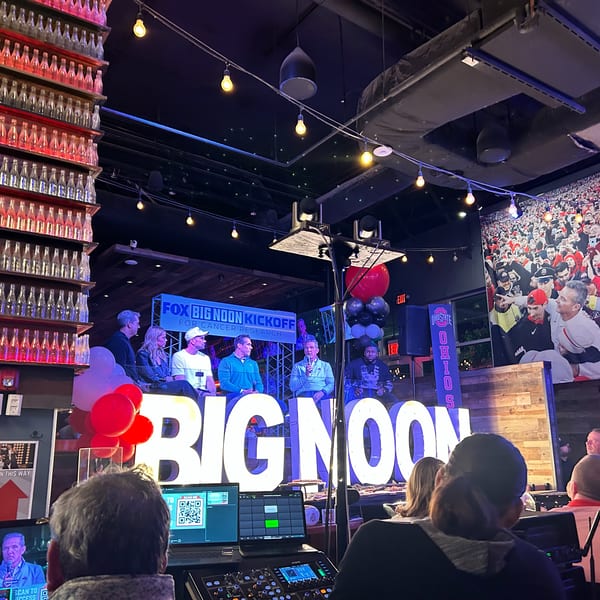 A panel of five men sit on a stage with "BIG NOON" in large letters, for a Fox Big Noon Kickoff event.